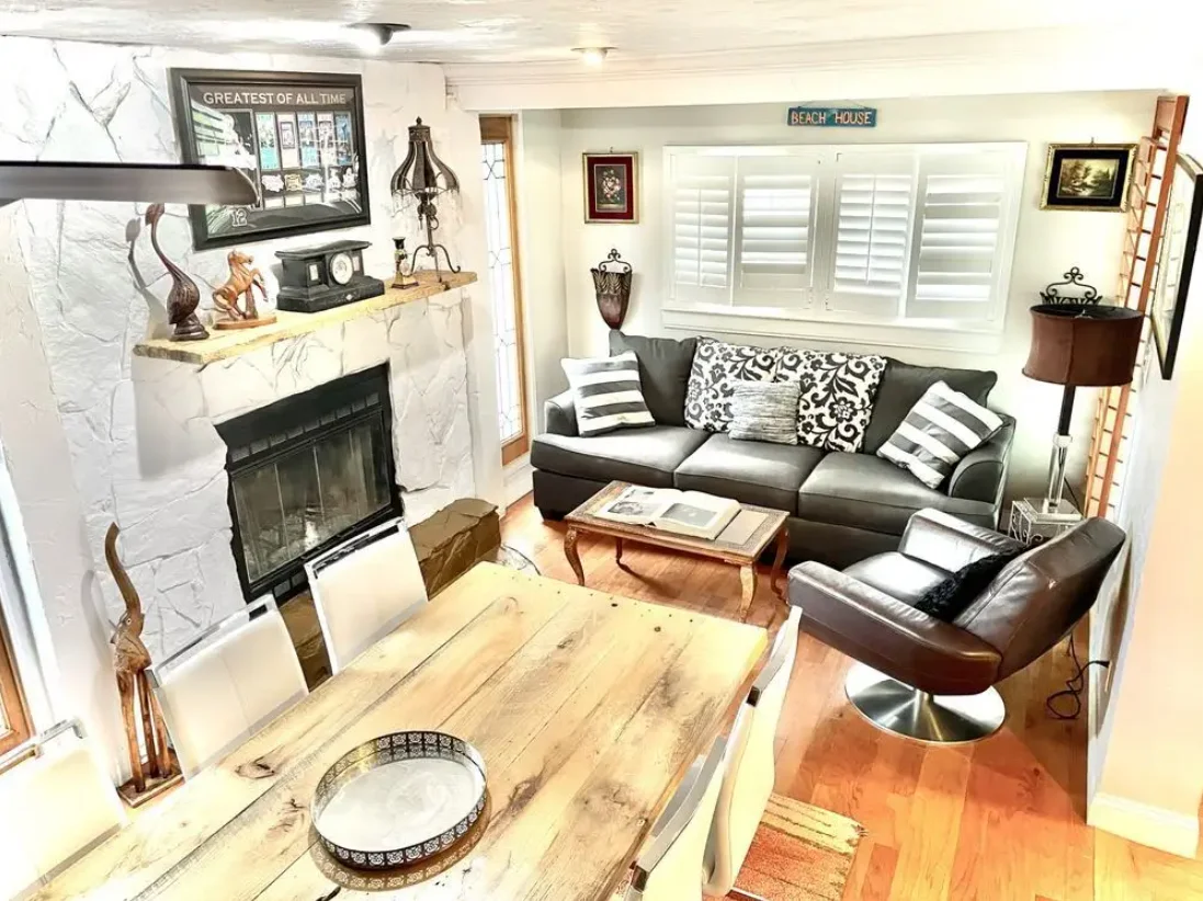 Cozy living room with fireplace, sofa, dining table, and beach house decor