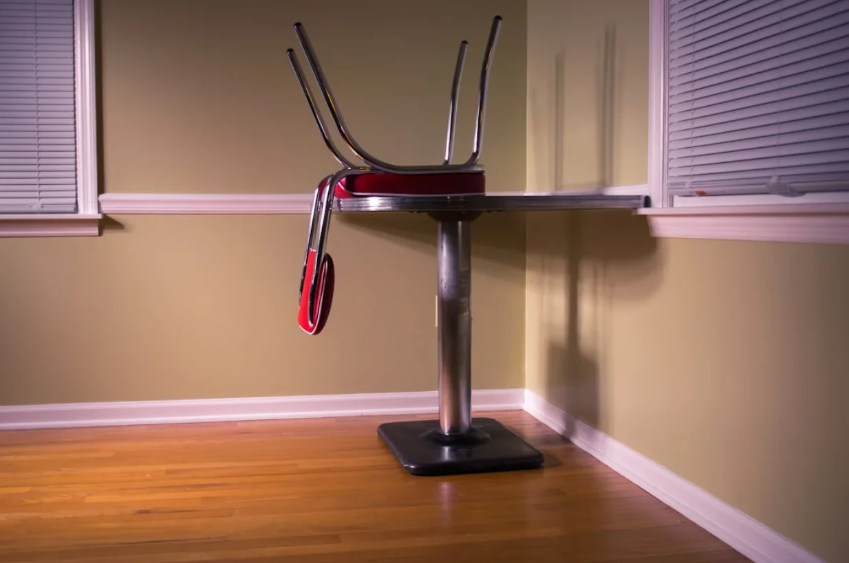 Stationary exercise bike with red accents and four antenna-like projections on a wooden floor indoors